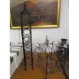 A wrought iron seven bottle wine rack, a similar magazine rack and a fire log basket