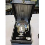 A cased silver cup, saucer and spoon with engraving