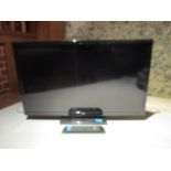 A Bush 30" flatscreen television on stand, together with a remote