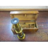 A small early 20th century brass field microscope in a mahogany case