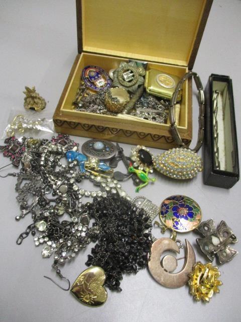 A mixed lot of mainly costume jewellery to include a Continental silver brooch, badges and other
