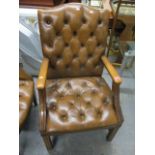 A reproduction brown leather, button back upholstered armchair