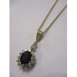 A sapphire and diamond drop necklace in a yellow metal mount and chain