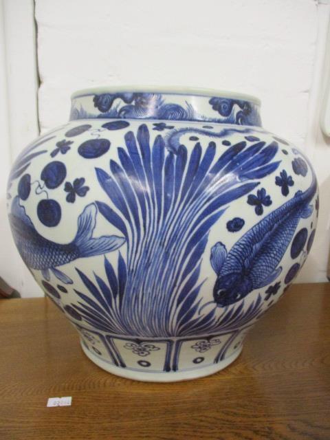 A 20th century Chinese fish bowl decorated in blue and white with fish swimming amongst reeds, 11