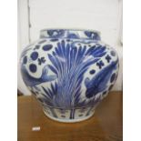 A 20th century Chinese fish bowl decorated in blue and white with fish swimming amongst reeds, 11