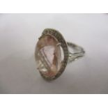 An 18ct white gold ring set with a pink stone and moissanite chips