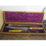 An early 20th century oak cased, antler handled carving set