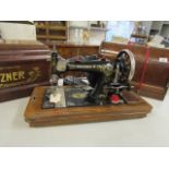 Two hand operated sewing machines, in walnut finished cases