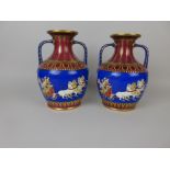 A pair of Hill Pottery Co two handled Etruscan Vases decorated scenes of horse drawn chariots on a