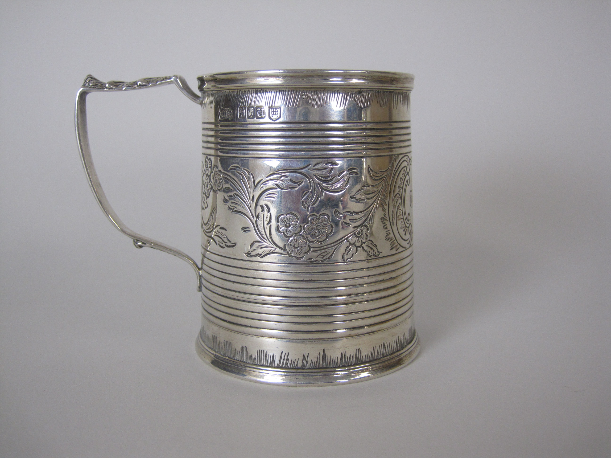 A George V Irish silver Christening Mug with reeded bands, floral and leafage frieze, engraved