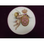 A Minton circular porcelain Plaque of winged cherub with oval monogram, coronet over, floral