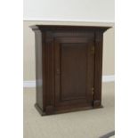 An 18th Century oak Wall Cupboard with dentil cornice above panelled door enclosing shaped shelves