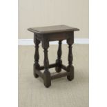 A 17th Century oak Joint Stool on baluster turned and square legs united by square stretchers, 16