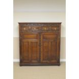 A William and Mary oak Press Cupboard having floral scroll carved frieze above a pair of mitre