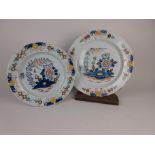 Two Lambeth Delft Chargers with floral decorated border, central stylised landscape design with