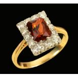 A Cluster Ring claw-set step-cut orange/red stone within frame of eight-cut diamonds, ring size R,