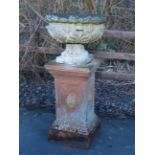 A terracotta Garden Urn with leafage moulded bowl on socle base and square pedestal decorated oval