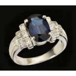 A Sapphire and Diamond Ring claw-set oval-cut stone, 2.85cts, between groups of channel-set