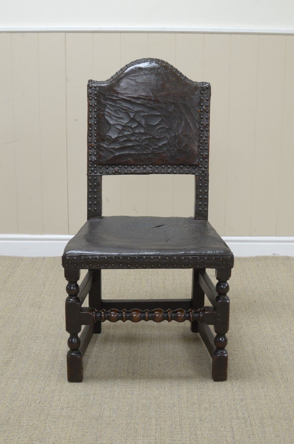 A late 17th Century oak Side Chair with leather upholstered back and seat on turned and square front