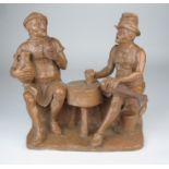 A terracotta Tavern Group depicting two Victorian tradesmen seated with beakers and a flagon of ale,