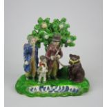 An unusual Staffordshire pottery Bear and Figure Group, c1820, the figures standing before a