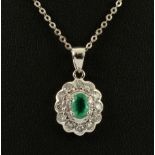 An Emerald and Diamond Pendant claw-set oval-cut emerald within a frame of twelve brilliant-cut