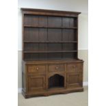 An antique oak Dog Kennel Dresser with boarded rack, the base fitted three drawers and pair of solid