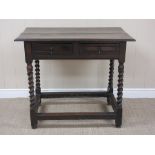 An antique oak Side Table fitted two short drawers on spiral turned supports united by square