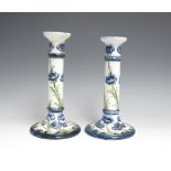 A pair of James Macintyre & Co Moorcroft Florian ware pottery Pillar Candlesticks decorated blue and