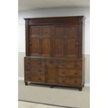 An early 19th Century oak Housekeeper's Cupboard with fluted and roundel frieze above pair of