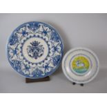 A 17th Century style maiolica blue and white Charger with central coat of arms and leafage surround,