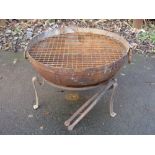 An iron Kadai with ring handles on stand with grill 28in D