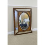 A 19th Century mahogany framed Wall Mirror with central oval bevelled panel having satinwood fan