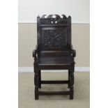 A 17th Century wainscot Armchair with leafage carved and pierced top rail, tulip, rosette and floral