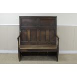 An 18th Century oak Settle with multi-panel back, shaped arms, solid seat, 4ft