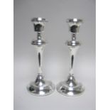 A pair of Elizabeth II silver Pillar Candlesticks with tapering columns on circular bases,