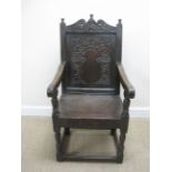 A 17th Century oak Wainscot Chair with leafage scroll carved top rail, trailing leafage carved panel