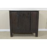 A primitive Welsh oak Cupboard with two plank door having replaced iron cockhead hinges, on square