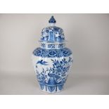 A large Delft blue and white baluster Jar and Cover painted peacocks and other birds amongst