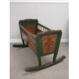 A 19th Century Continental pine Crib painted panels of flowers on a red ground with green