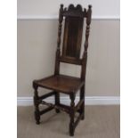 A late 17th Century oak Side Chair with scroll carved top rail, plain panel back, solid seat on