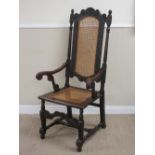 A Carolean walnut Armchair with scallop and scroll carved top rail, cane panelled back and seat,