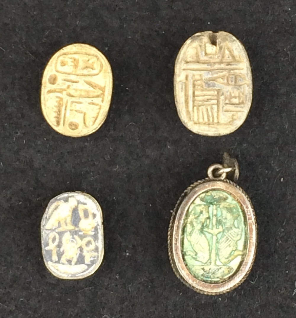 A collection of four Egyptian Scarabs, comprising an 18th Dynasty cream steatite scarab with