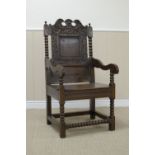 A Charles II oak Wainscot Armchair with leafage scroll carved cresting rail, plain square panel back