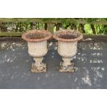 A pair of cast iron Garden Urns with lobed rims, fluted bodies on square bases, 24in