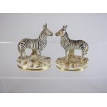 A rare pair of small 19th Century porcelain Zebras with painted details on oval bases having