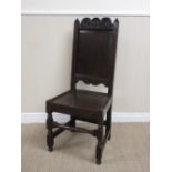 A 17th Century oak Side Chair with scroll and rosette carved top rail, plain panel back, solid