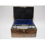 A Victorian burr walnut Dressing Case with engraved silver lidded fittings, mirror in lid, drawer to