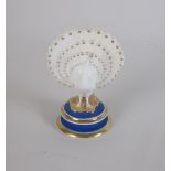 A Chamberlain, Worcester Model of a Peacock on a circular base with blue and gilt details, 3 1/4 in,