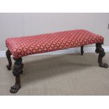 A 19th Century Footstool with red and gold cushioned seat upon scroll and leafage carved supports